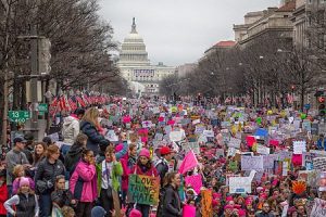 people mostly women marching in Washington DC carrying signs protesting Donald Trumps election